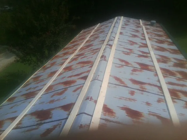 Rusted metal roof panels with new wood purlins before replacement — Storm Damage Roof Repair in Caddo Mills by Roofing Brothers