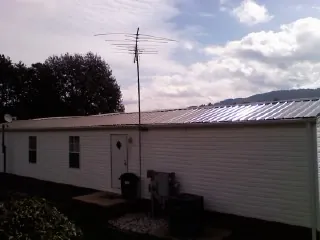 New metal roof on a single wide mobile home with a TV antenna in Caddo Mills