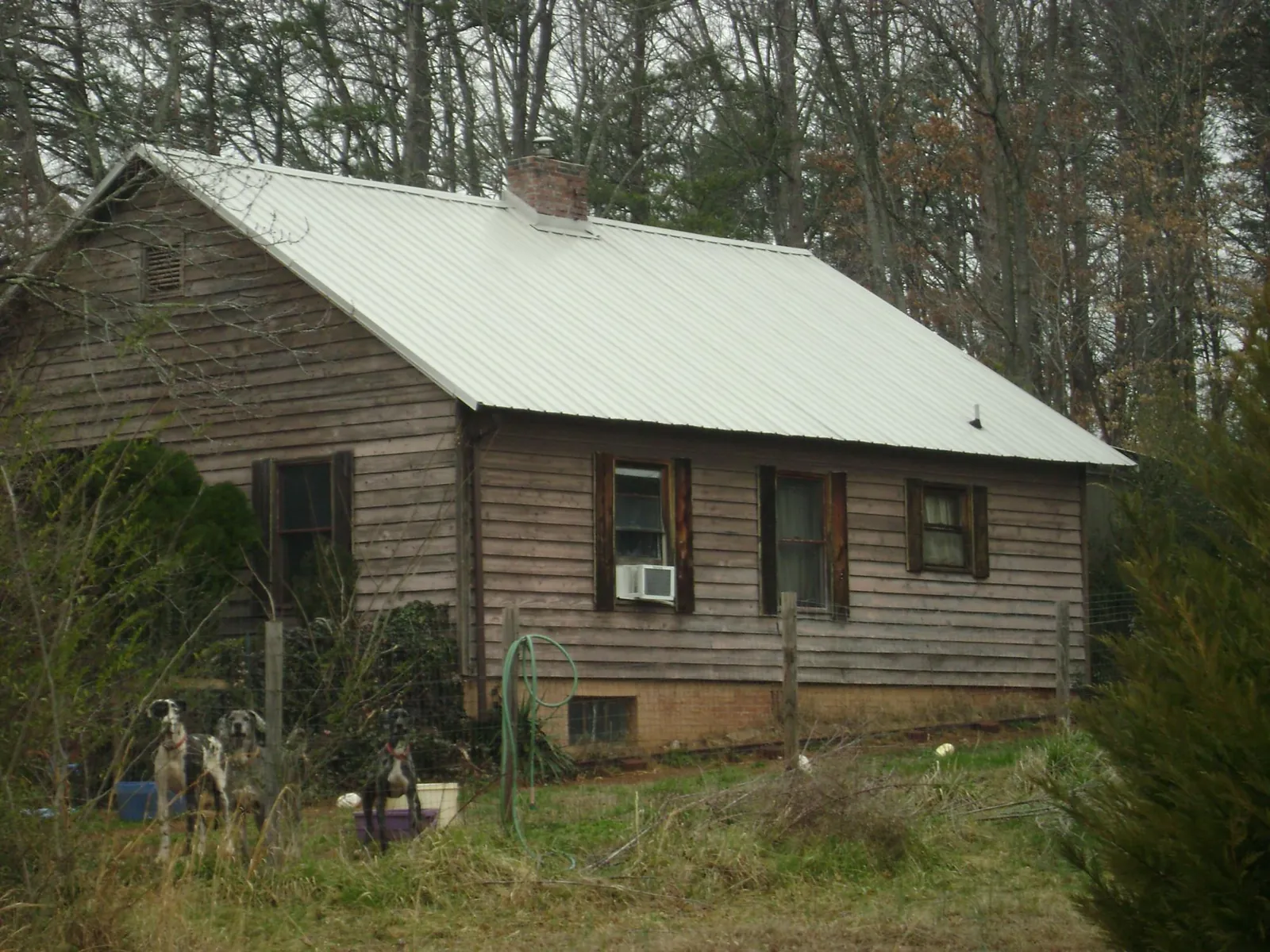 White metal roof on an old wood sided farmhouse, from a Metal Roof Installation job in Caddo Mills